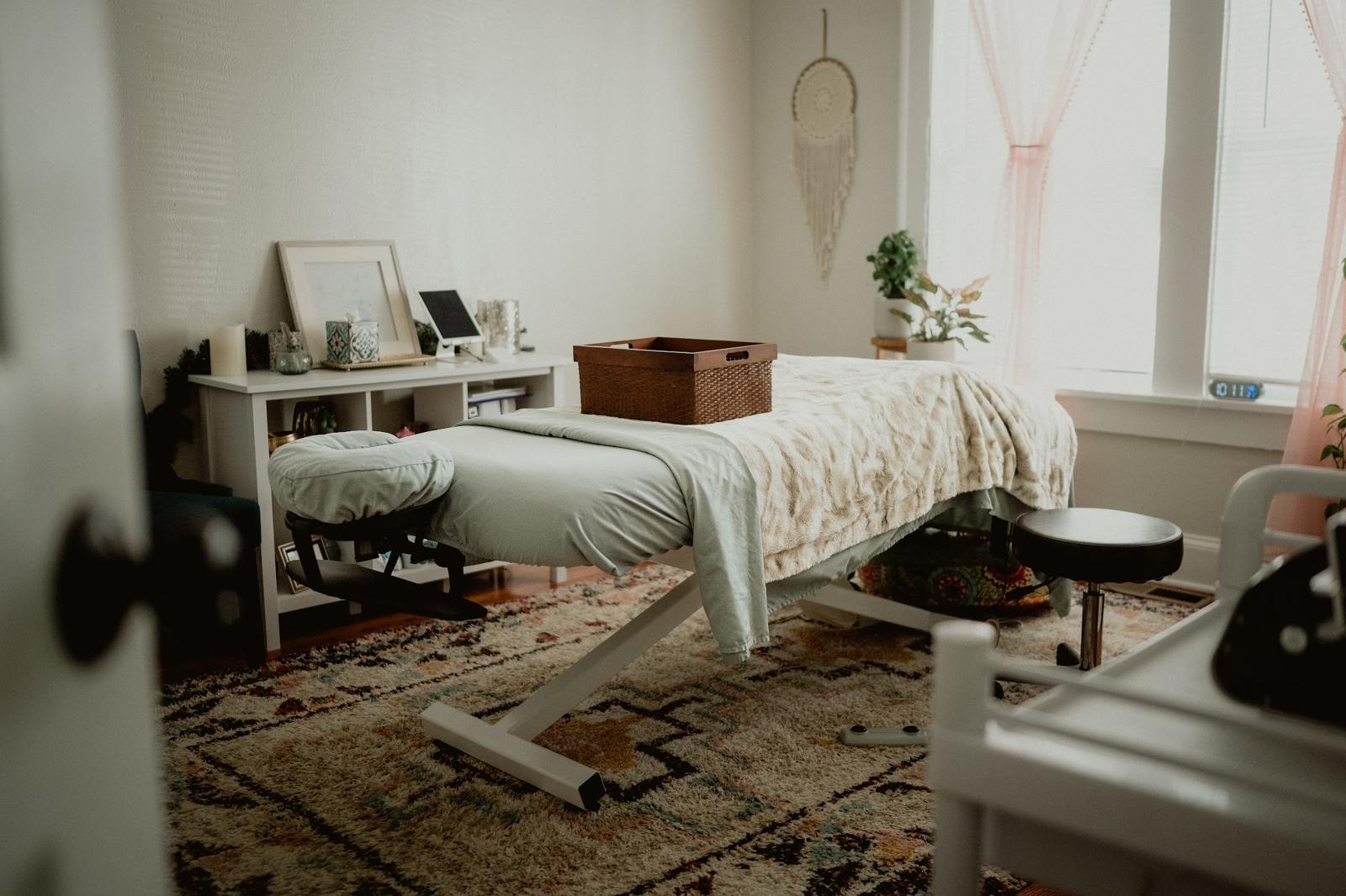 Our treatment room with a massage table, rug and plants