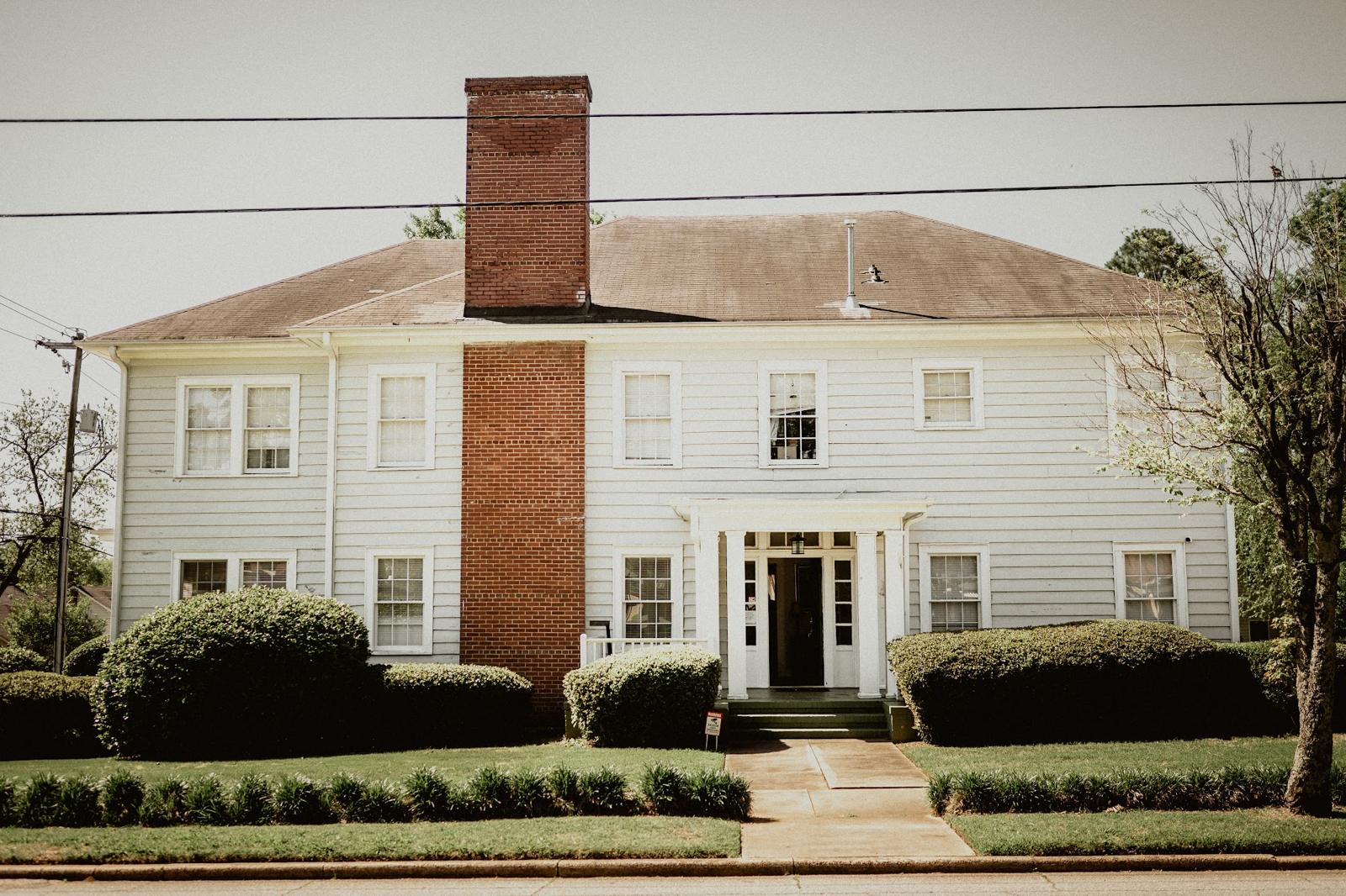 The white two-story house at East Poplar Gardens, 228 East Poplar Street, Griffin