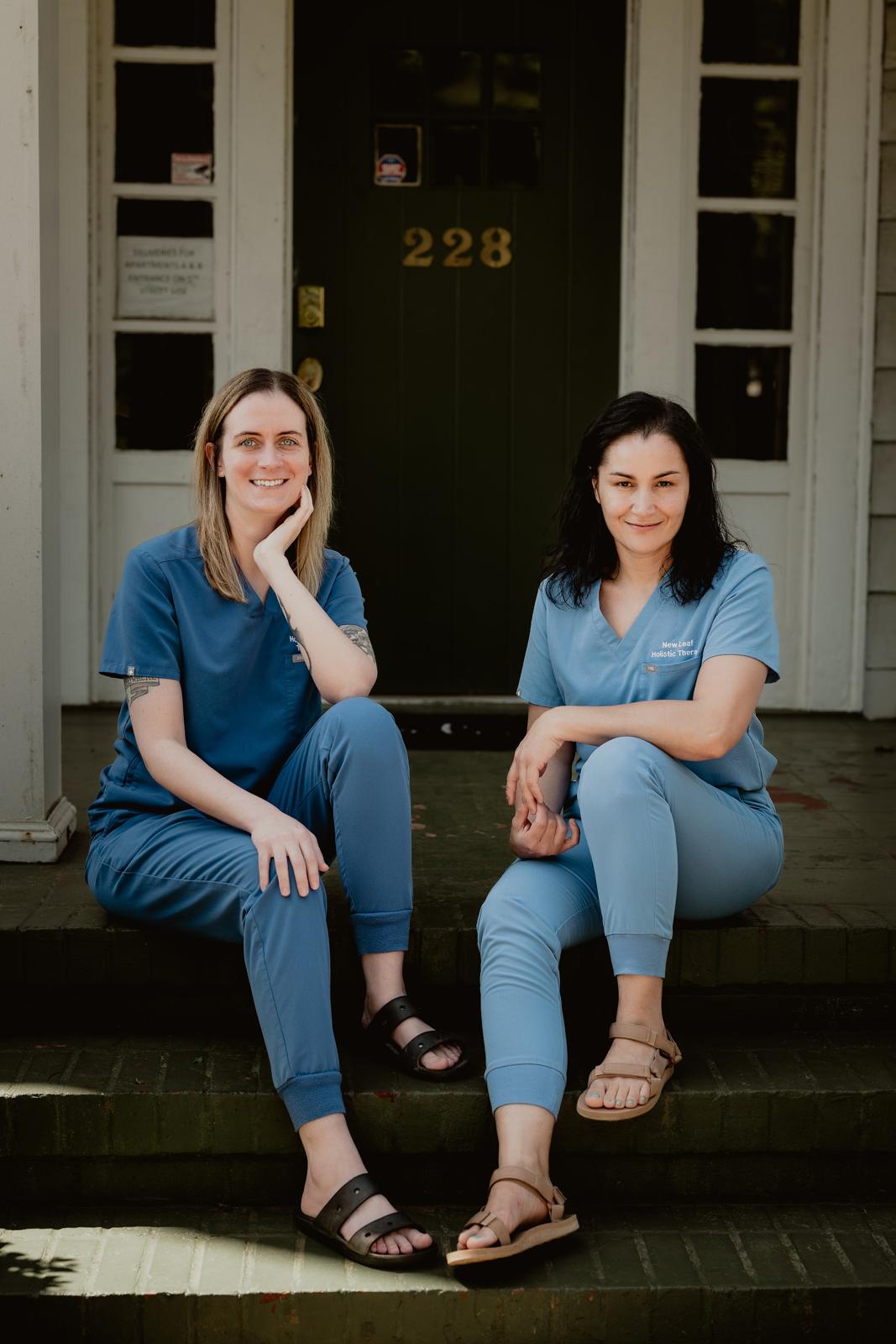 Two of our therapists sitting on the front steps of 228